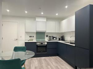 a kitchen with blue and white cabinets and a glass table at Kinzo's Apartment in Chatham