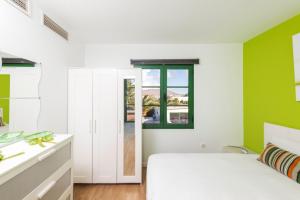 a bedroom with a white bed and green walls at Villa Casa Aloe Vera in Playa Blanca