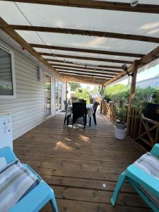 eine Terrasse mit 2 Betten, einem Tisch und Stühlen in der Unterkunft Camping Del Mar 264, Mobile Home Excellence, 3 chambres, 6 personnes, 2 Salles de Bain, bord de mer in Argelès-sur-Mer