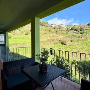 a balcony with a table with a plant on it at Green House in Calheta +43 photos