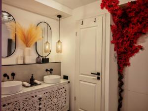 a bathroom with two sinks and red flowers at Stilvolle Suite im Herzen von Landau in Landau in der Pfalz +48 photos