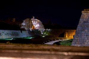 a bridge with a building in the background at night at A Muralha in Almeida