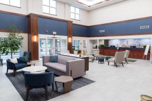 a waiting room with couches and tables and chairs at La Quinta by Wyndham Bannockburn-Deerfield in Bannockburn