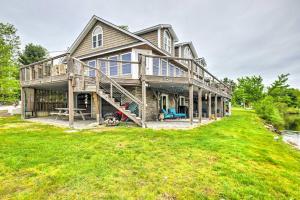 a large wooden house on a grass field at Lake Front Enfield Home with Deck & Boat Dock! in Enfield