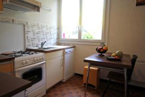 a kitchen with a stove and a table with a bowl of fruit at Dominant l'etang in Compreignac