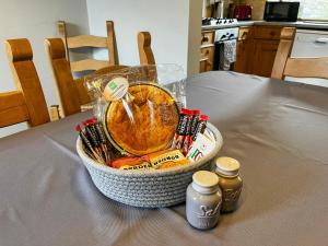 ベイクウェルにあるTom Wragg Suite - Uk40248のテーブルの上には2本のボトルが置かれた食べ物の入ったバスケット