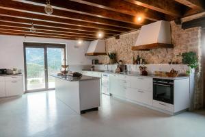 a large kitchen with white cabinets and appliances at Olabe hostel in Ea
