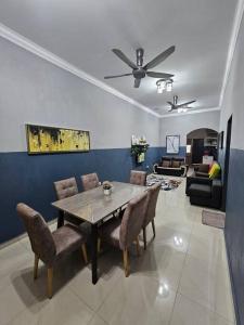 a living room with a wooden table and chairs at Berjaya Homestay Mutiara Semantan in Temerloh