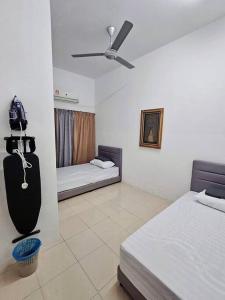 a bedroom with two beds and a ceiling fan at Berjaya Homestay Mutiara Semantan in Temerloh +4 photos