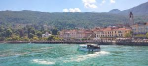 a boat in a river in front of a town at DOBA House in Baveno