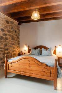 a wooden bed in a room with a stone wall at Olabe in Ea