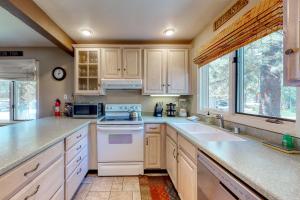 Una cocina con electrodomésticos blancos y gabinetes de madera. en Wildflower 47, en Mammoth Lakes