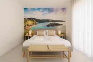 ein Schlafzimmer mit einem Bett und einem Gemälde eines Strandes in der Unterkunft Villa Lola in Mariquiteira