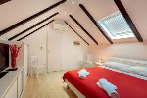 a bedroom with a red bed and a window at Hedera Estate Villa Hedera XI in Koločep