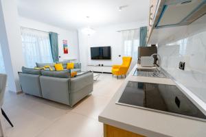 a kitchen and living room with a couch and a tv at Kotarja Apartments in Dhërmi