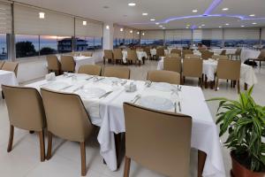 a dining room with white tables and chairs at AGZ Hotel in Dikili +64 photos