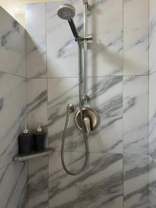 eine Dusche mit Duschkopf in einem Badezimmer in der Unterkunft Charming apartment 2 bedroom 2 bath in Baños