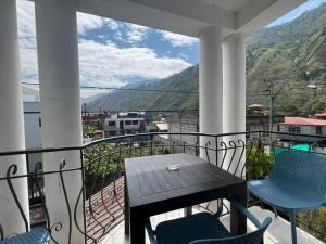 eine Veranda mit einem Tisch und Stühlen auf dem Balkon in der Unterkunft Charming apartment 2 bedroom 2 bath in Baños