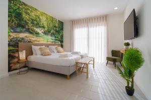 ein Schlafzimmer mit einem Bett und einem Gemälde an der Wand in der Unterkunft Villa Lola in Mariquiteira