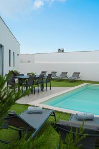 eine Terrasse mit Tischen und Stühlen neben einem Pool in der Unterkunft Villa Lola in Mariquiteira