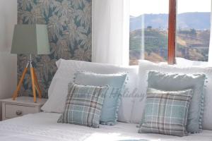 a bed with white pillows and a window with a view at Piso Amaranta, Frigiliana Modern 2 bedroom, 2 bathroom Apartment with Air conditioning and Pool HansOnHoliday Rentals in Frigiliana +26 photos