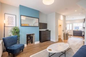 a living room with a blue wall with a fireplace at Beautiful 2bed Central Home in Cambridge