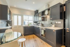 a kitchen with gray cabinets and a glass table at Beautiful 2bed Central Home in Cambridge