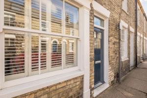 a window with blinds on a brick building at Beautiful 2bed Central Home in Cambridge