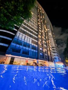 a building with a large blue pool in front of it at 1 Bedroom Apartment in Aeon Towers I City Views I Free Wi-fi, Gym and Pool in Davao City