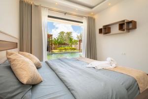 a bedroom with a large bed with a large window at Villa Cookie le Coquin, 3 chambre au centre de Grand Baie, jacuzzi in Grand Baie +110 photos
