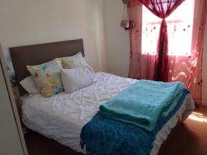 une chambre avec un lit avec des oreillers et une fenêtre dans l'établissement Kenda house, au Cap