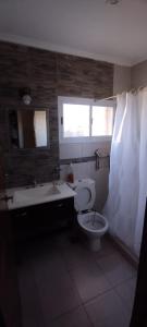 ein Badezimmer mit Toilette und Waschbecken und einem Fenster in der Unterkunft Santa Elena Casa de Campo in Federación