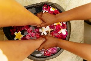 two hands reaching for flowers in a bowl of water at Kisiwa on the Beach in Paje