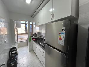 a kitchen with a stainless steel refrigerator and white cabinets at Apartment in Al Hoceima in Al Hoceïma