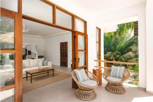 a living room with two chairs and a couch at Kisiwa on the Beach in Paje