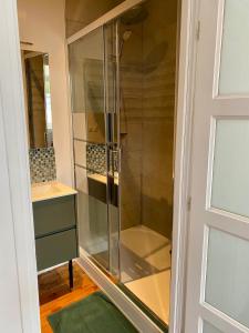 a glass shower in a bathroom next to a door at Gîte de la tour carrée in Bergues +30 photos