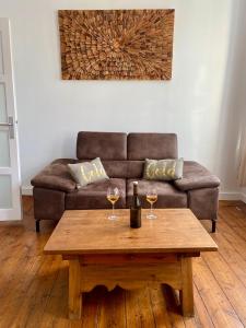 a living room with a couch and a table with wine glasses at Gîte de la tour carrée in Bergues