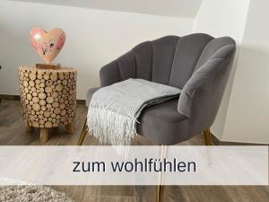 una silla gris junto a una mesa en una habitación en Ferienwohnung Rambold Wettersteinwand, en Garmisch-Partenkirchen