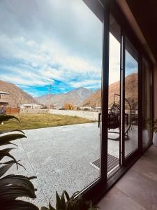 a view from a window of a patio with mountains at Alpine Escape Kazbegi in Kazbegi