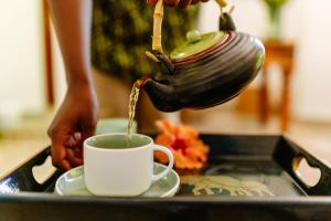 a person pouring coffee into a cup on a tray at Kisiwa on the Beach in Paje