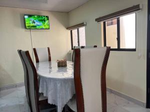 jadalnia ze stołem z krzesłami i telewizorem w obiekcie Sanctuary Apartment 5 bedroom 4 bathroom w Baños