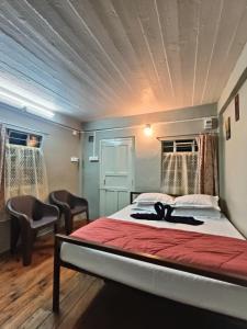 una camera con un letto e sedie di The Cozy Nest Homestay Shillong a Shillong