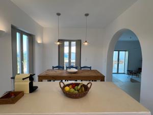 a kitchen and dining room with a basket of fruit on a table at Saliagos villas complex with private pools in Antiparos