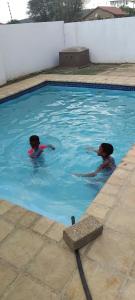 2 personas nadando en una piscina en Tsoga Odire guest House, en Ledig