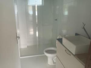 ein weißes Badezimmer mit Dusche und Toilette in der Unterkunft Casa na praia in Pontal do Paraná