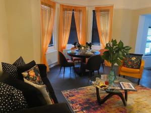 a living room with a couch and a table and chairs at The Bell's Self-Service Holiday Flat Bournemouth in Bournemouth