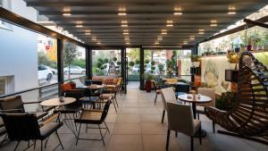 a restaurant with tables and chairs and windows at F&M Hotel 2 in Tirana