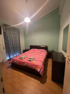 ein Schlafzimmer mit einem Bett mit roter Bettdecke in der Unterkunft Maisonette Stella in Kardítsa
