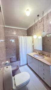 a bathroom with a toilet and a sink and a mirror at Casa Sol e Mar by Férias em Figueira in Figueira da Foz