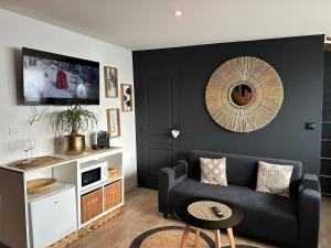 un soggiorno con un divano e una TV di Love Room & Spa, L'Atelier des Sens a Mons-en-Pévèle